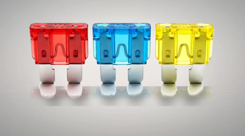 Standard ATO blade fuses arranged in red 10A blue 15A and yellow 20A colors for automotive circuit protection